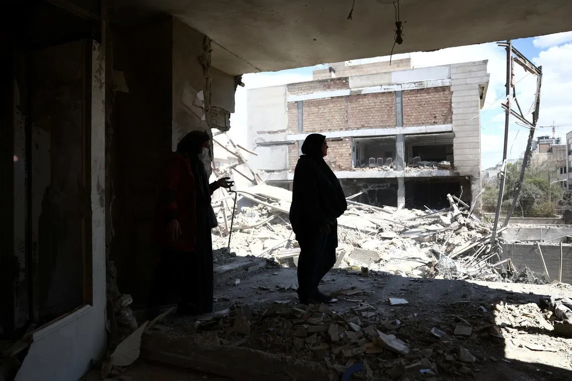 A woman stands in her brother's home, which was damaged by a strike, as the U.S.-Israeli conflict with Iran continues, in Tehran, Iran, March 30, 2026.