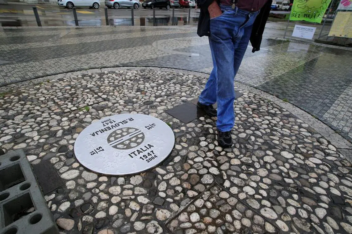 FILE PHOTO: A man walks at the European Union square at the border between Slovenia and Italy, as the coronavirus disease (COVID-19) travel restrictions across Europe are gradually eased, in Nova Gorica, Slovenia, June 15, 2020. REUTERS/Borut Zivulovic/File photo