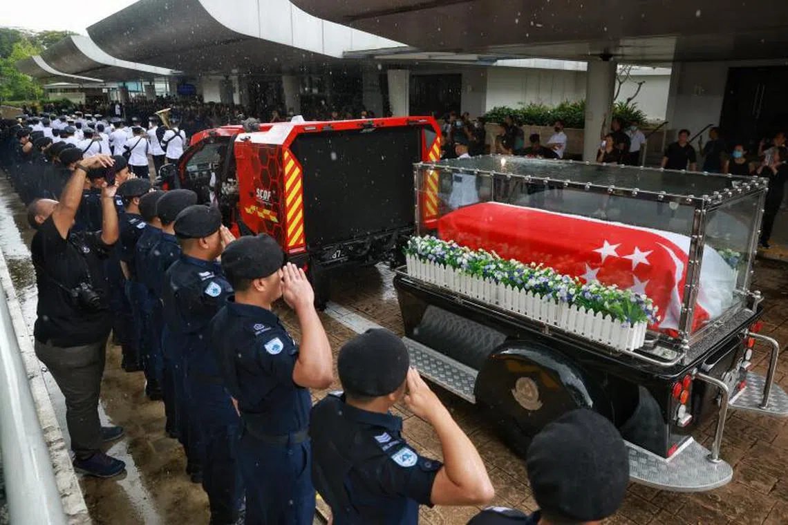 Singapore Civil Defence Force personnel saluting the hearse of Sergeant (1) Edward H. Go during a ceremonial procession on Dec 13, 2022.