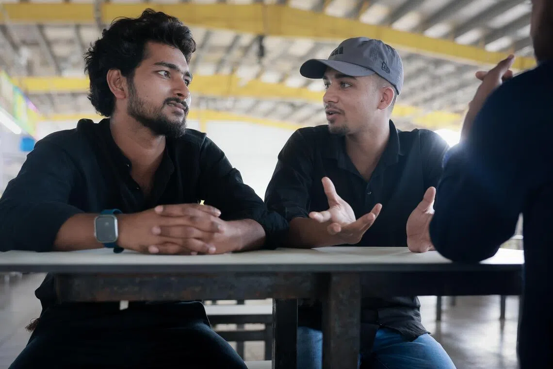 Shah Md Towid (with beard) and Hussain Md Sabbir (wearing a cap) chat with a friend at a foreign worker dormitory in Tuas on June 26, 2026. The two Bangladeshis were affected by an alleged abandonment case and had not been paid their wages.