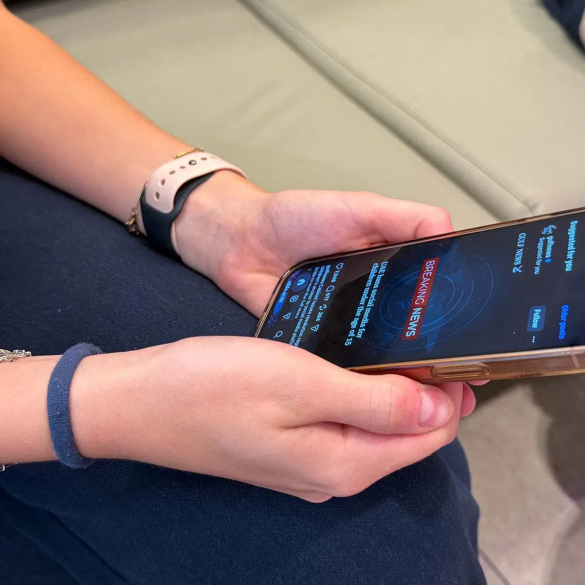 A teenage girl holds her mobile phone displaying a news alert on social media, after the United Arab Emirates approved a resolution setting the minimum age for social media use at 15, in Dubai, United Arab Emirates, June 18, 2026. Picture taken with a mobile phone. REUTERS/Rula Rouhana