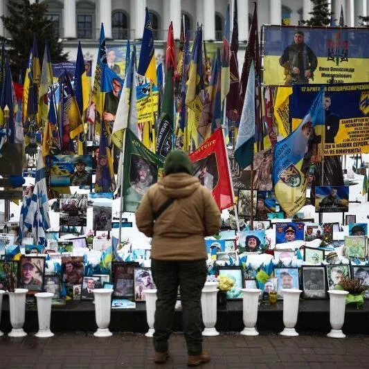 A person stands at a makeshift memorial to fallen soldiers in Kyiv, Ukraine, on Feb 23, 2026, as the conflict with Russia reaches its four-year mark.