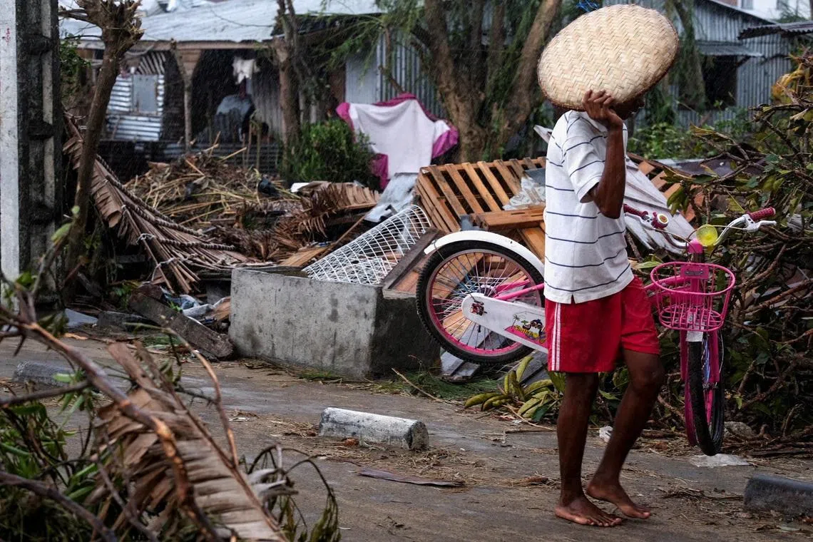 A man walks with his belongings after Cyclone Gezani tore through the port city of Toamasina, on the island of Madagascar, leaving a trail of destruction, February 12, 2026. REUTERS/Stringer