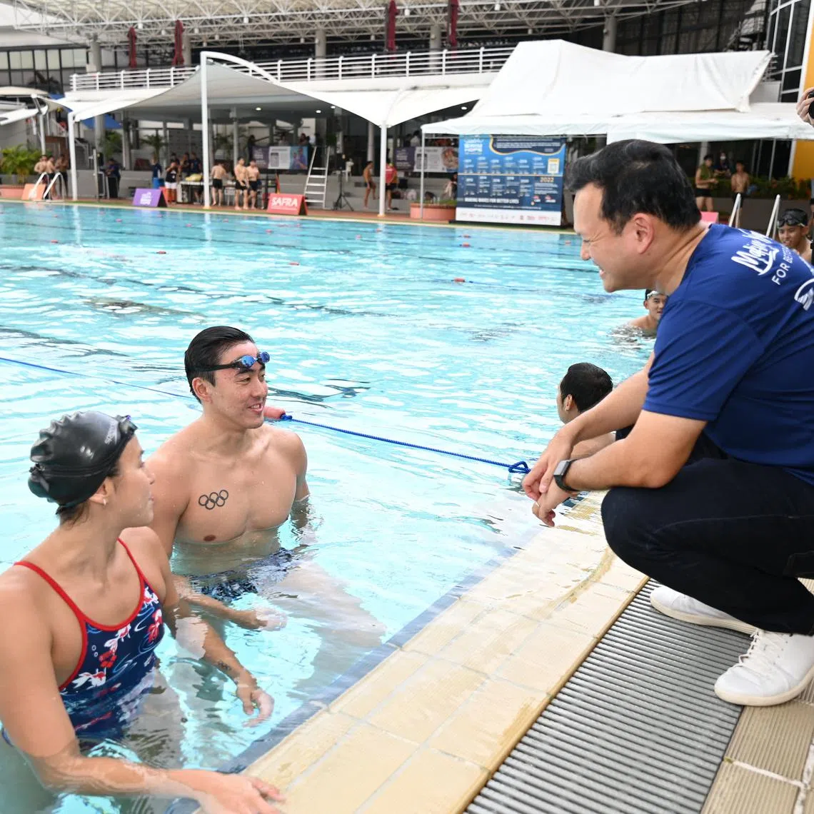 Senior Minister of State for Defence and Safra president Zaqy Mohamad interacting with national swimmers Quah Zheng Wen and Quah Ting Wen during the Safra Swim for Hope 2022.