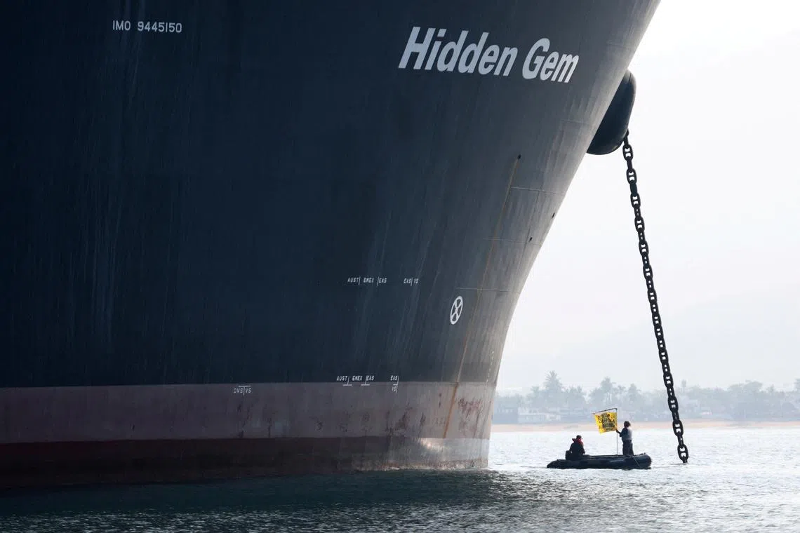 FILE PHOTO: A Greenpeace activist holds a banner during a protest near the deep sea mining vessel Hidden Gem, commissioned by Canadian miner The Metals Company, in the Mexican Pacific port of Manzanillo, in Manzanillo, Mexico September 27, 2023. Gustavo Graf/Greenpeace Mexico/Handout via REUTERS/File Photo