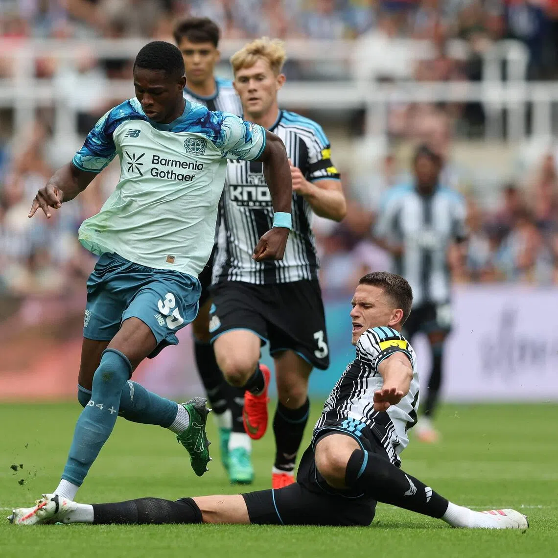 Newcastle United defender Sven Botman (right) tackling Bayer Leverkusen striker Christian Kofane before Newcastle changed their kit.