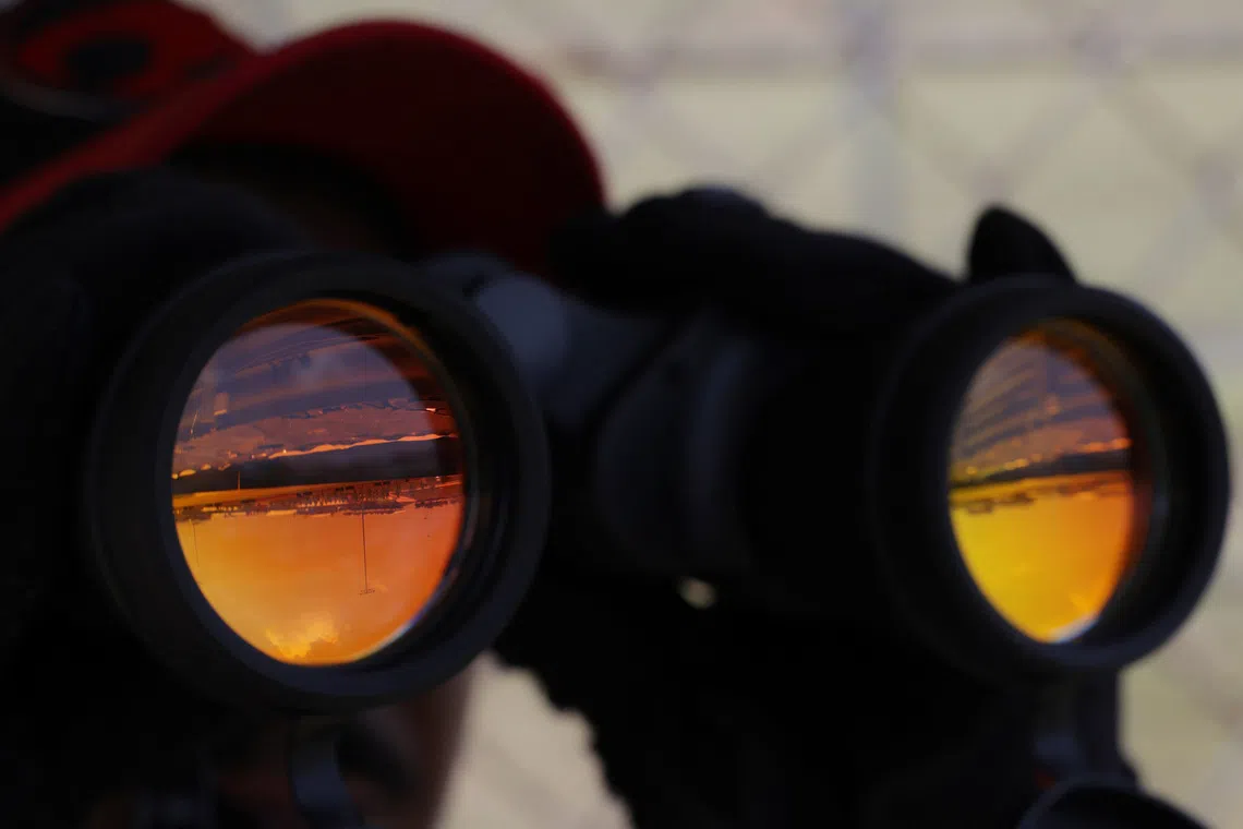 Formula One F1 - Bahrain Grand Prix - Sepang International Circuit, Sepang, Malaysia - October 2, 2026 A fan watches on with binoculars during practice 1 REUTERS/Annice Lyn