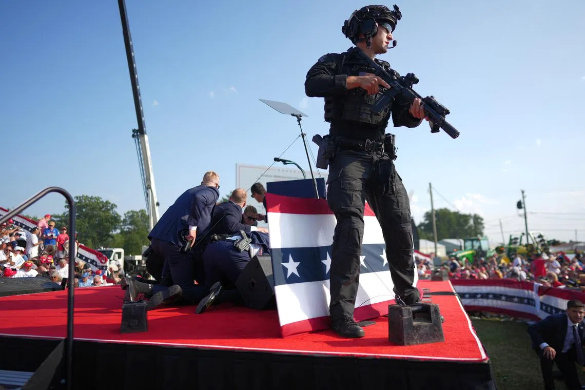 Secret Service agents cover former President Donald Trump immediately after shots were fired in an assassination attempt at a campaign rally in Butler, Pennsylvania on July 13.