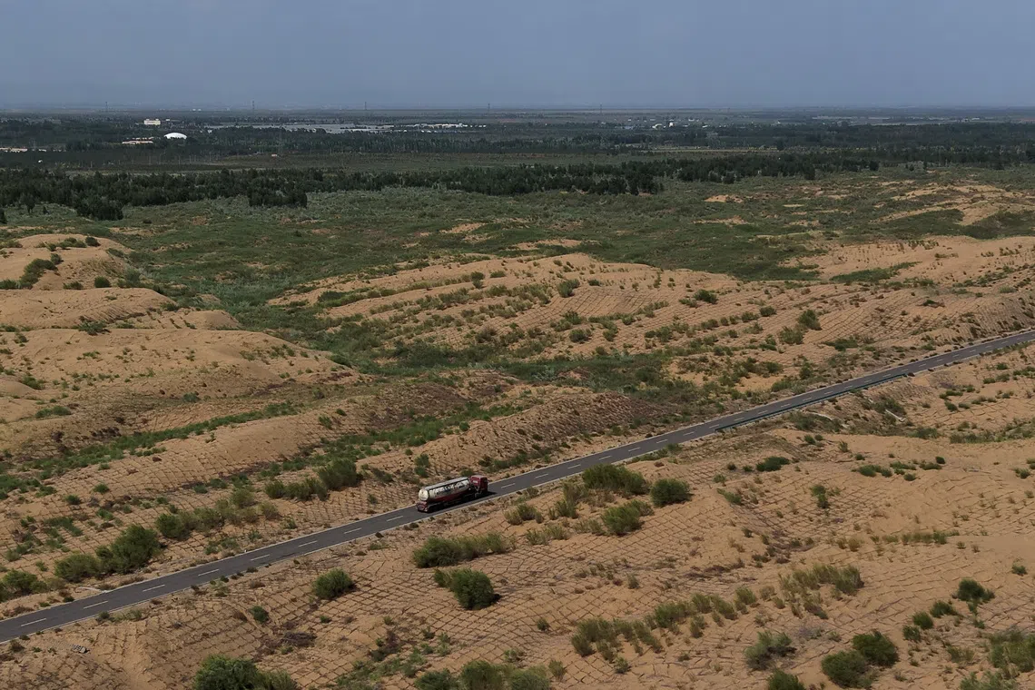 FILE PHOTO: A drone view shows a truck driving along a road at an antidesertification site, with square grids of branches sticked into the ground to prevent sand movement, in Kubuqi desert during an organized media tour, in Ordos, Inner Mongolia Autonomous Region, China, June 12, 2026. REUTERS/Maxim Shemetov/File Photo