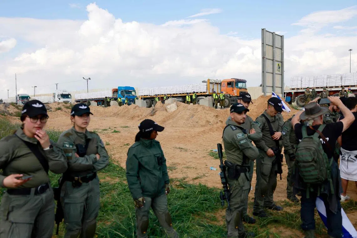 Israeli security forces stand guard in front of trucks on the sidelines of a demonstration on Jan 29, 2024.