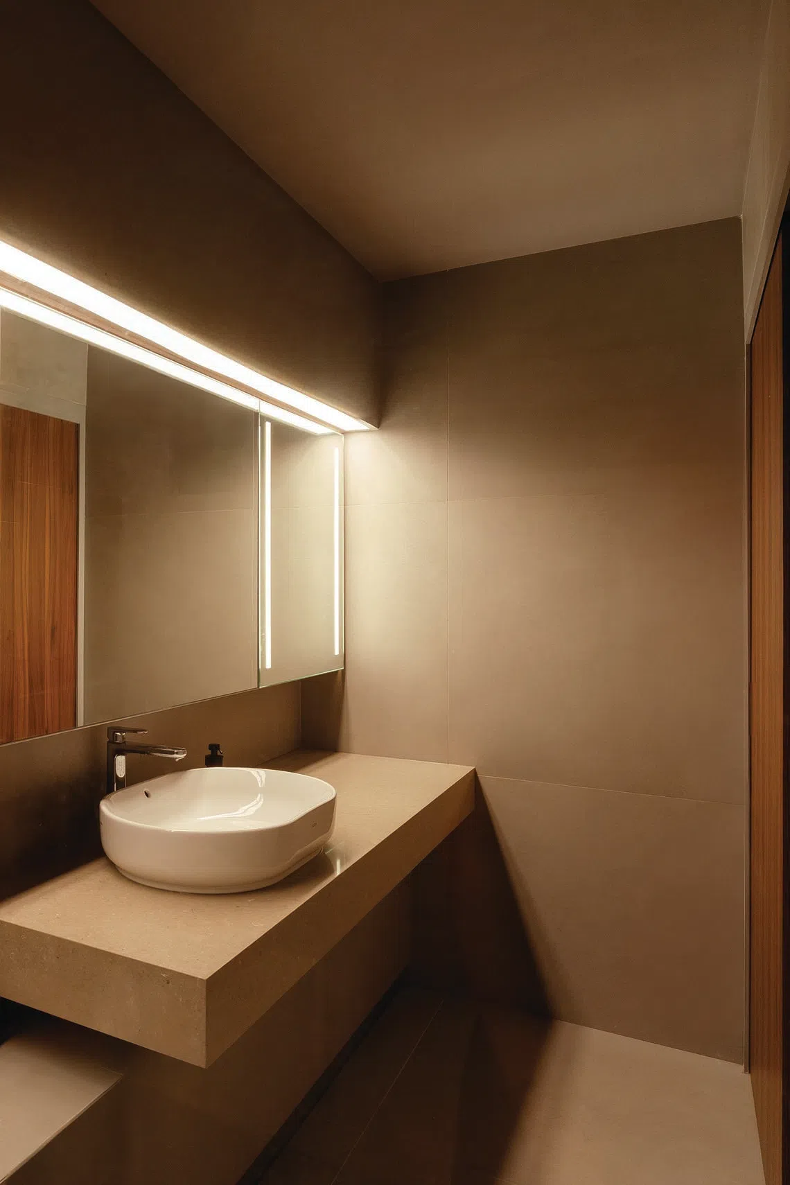 Os azulejos macios e a iluminação integrada conferem ao banheiro principal uma atmosfera relaxante.