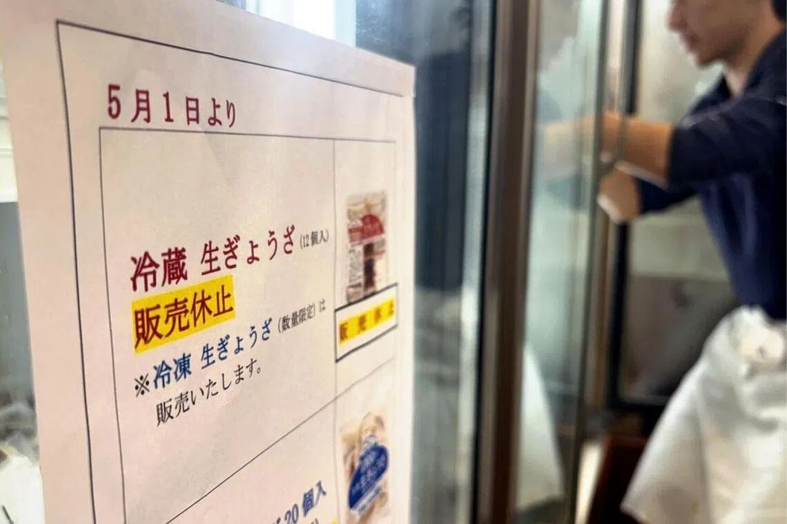 A sign notifying customers that sales of refrigerated gyoza dumplings will be suspended from May 1.