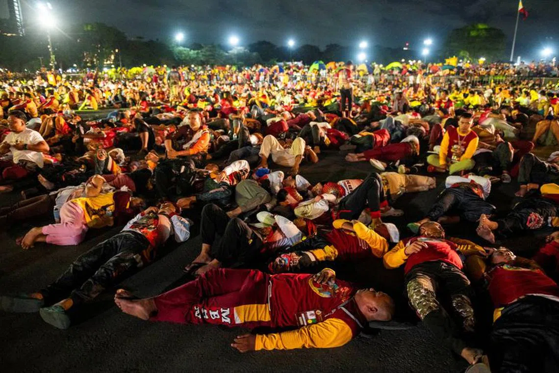 Filipino devotees rest while waiting for the procession of the Black Nazarene to begin, during its feast day and annual procession, in Manila, Philippines, January 9, 2024. REUTERS/Lisa Marie David