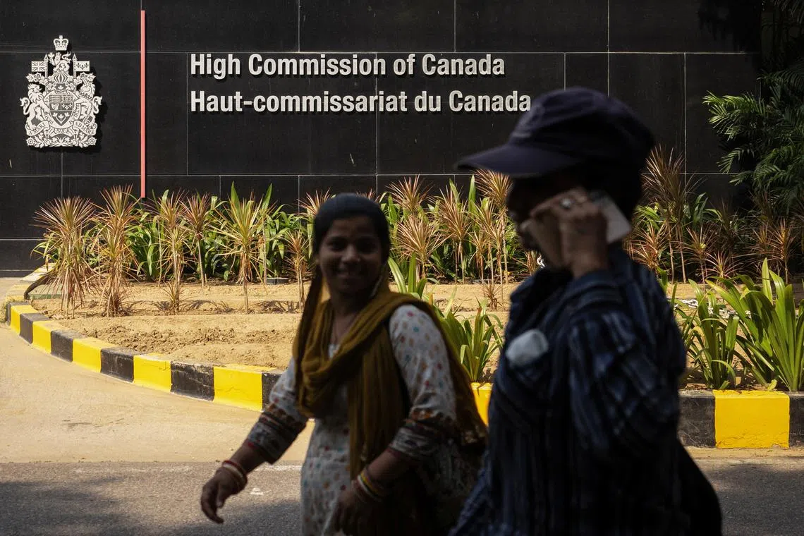 FILE PHOTO: Women walk past the main gate of the Canadian High Commission, in New Delhi, India October 17, 2024. REUTERS/Adnan Abidi/File Photo