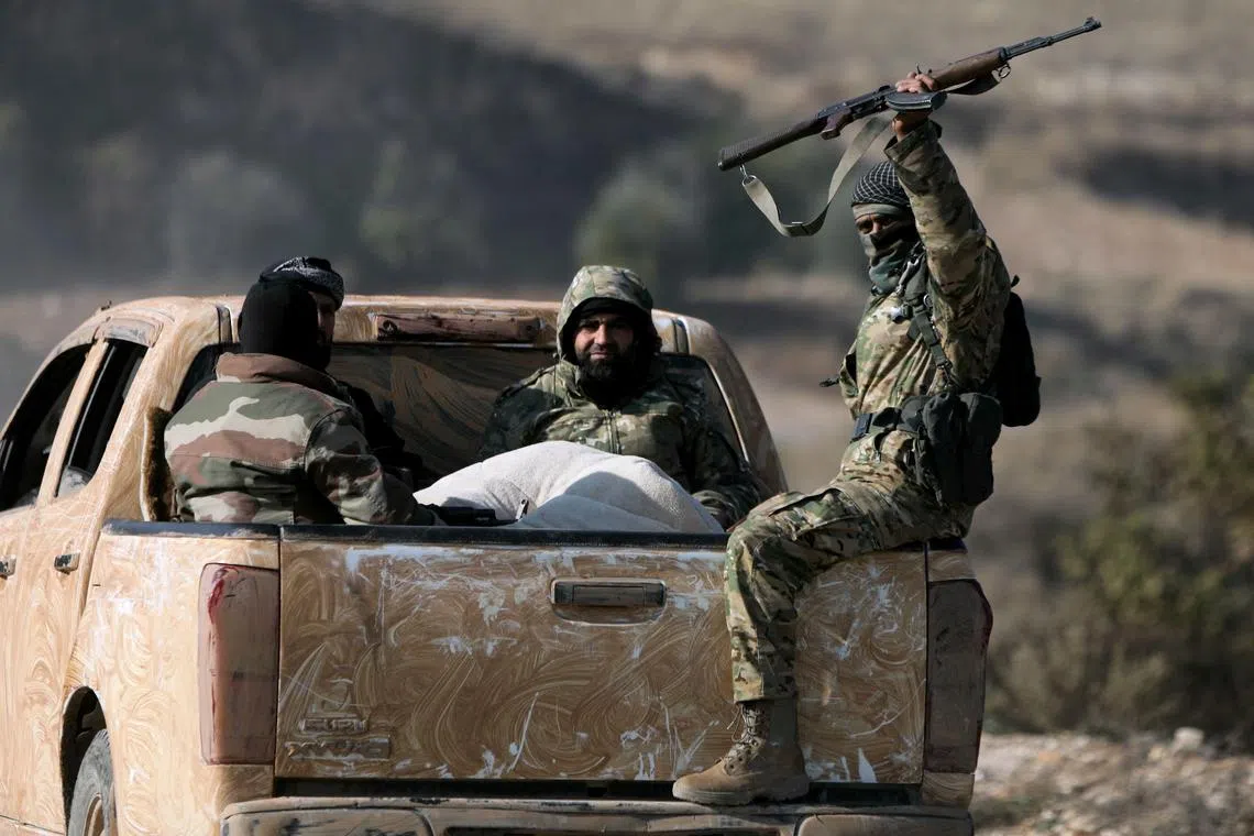 Anti-government fighters riding in the back of a pick truck in the town of Suran, between Aleppo and Hama, on Dec 3.