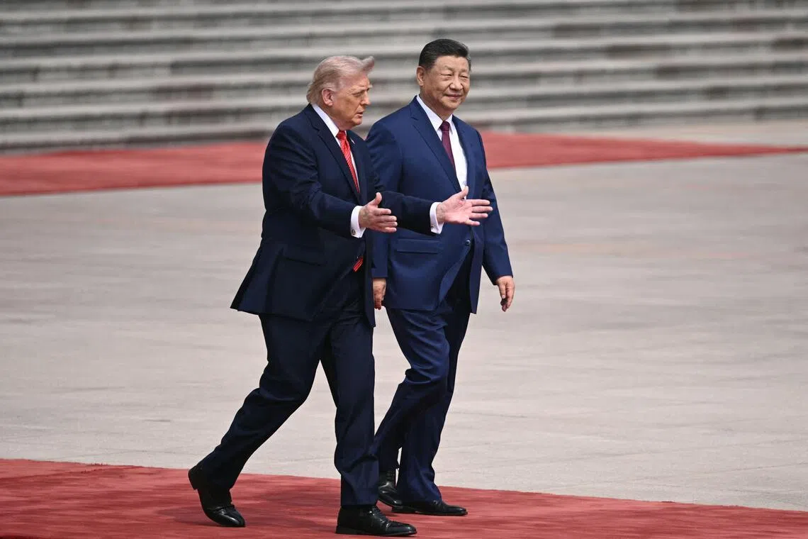 US President Donald Trump (left) takes part in a welcome ceremony with China's President Xi Jinping at the Great Hall of the People in Beijing on May 14, 2026.