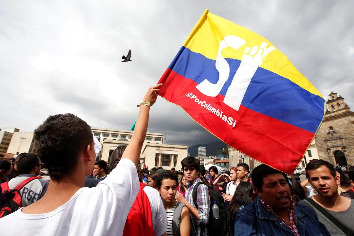 FILE PHOTO: University students and supporters of the peace deal signed between the government and Revolutionary Armed Forces of Colombia (FARC) rebels display a flag during a rally in front of Congress in Bogota, Colombia, October 3, 2016. REUTERS/John Vizcaino/File Photo