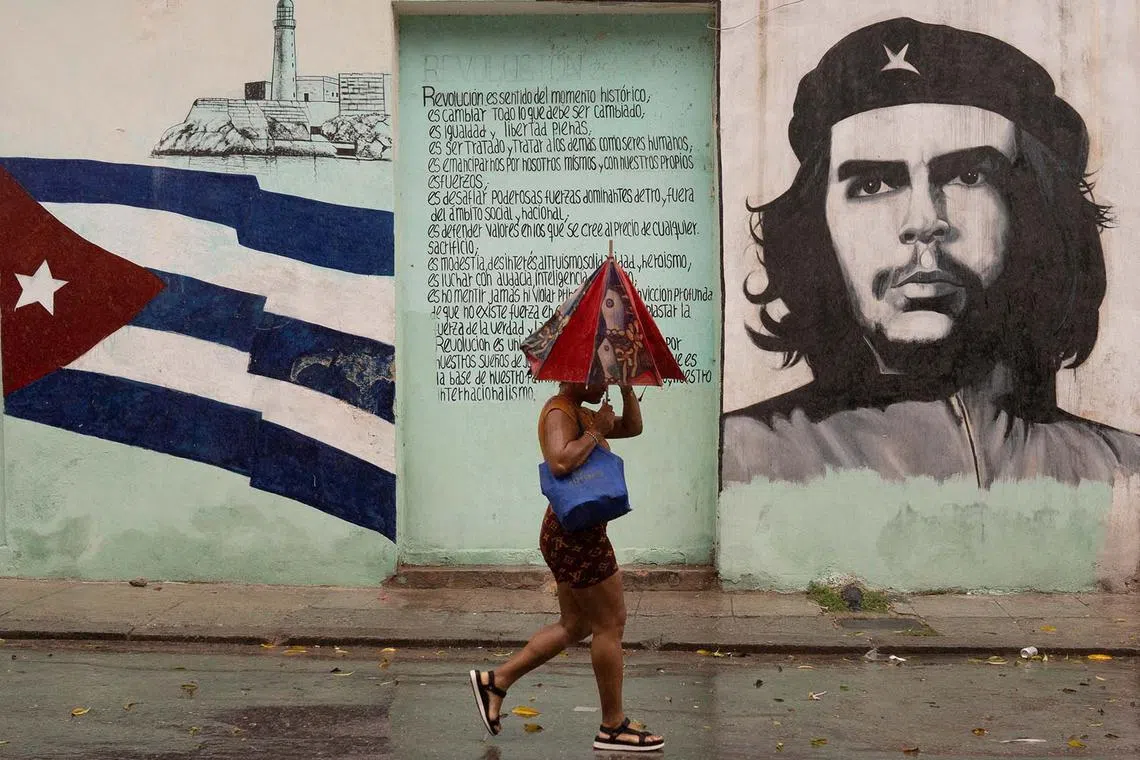 A woman walking on the street as Hurricane Rafael passes by Havana, Cuba, Nov 6, 2024. 