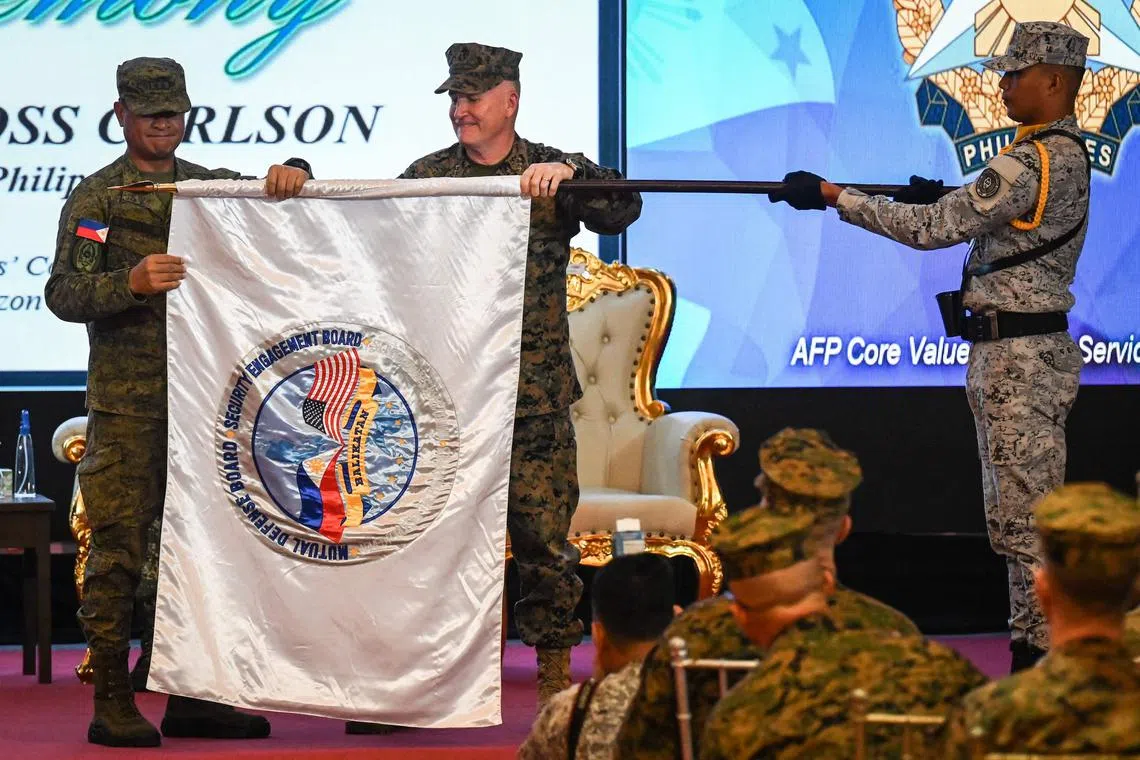 Philippines exercise director for Balikatan Major-General Marvin Licudine (left) and US exercise director for Balikatan Lieutenant General William Jurney (right) unfurl the exercise flag during the opening ceremony of the 'Balikatan' joint military exercise.