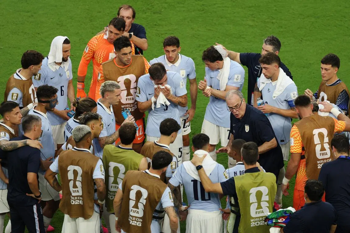 Uruguay coach Marcelo Bielsa speaks to his players during the second half hydration break.