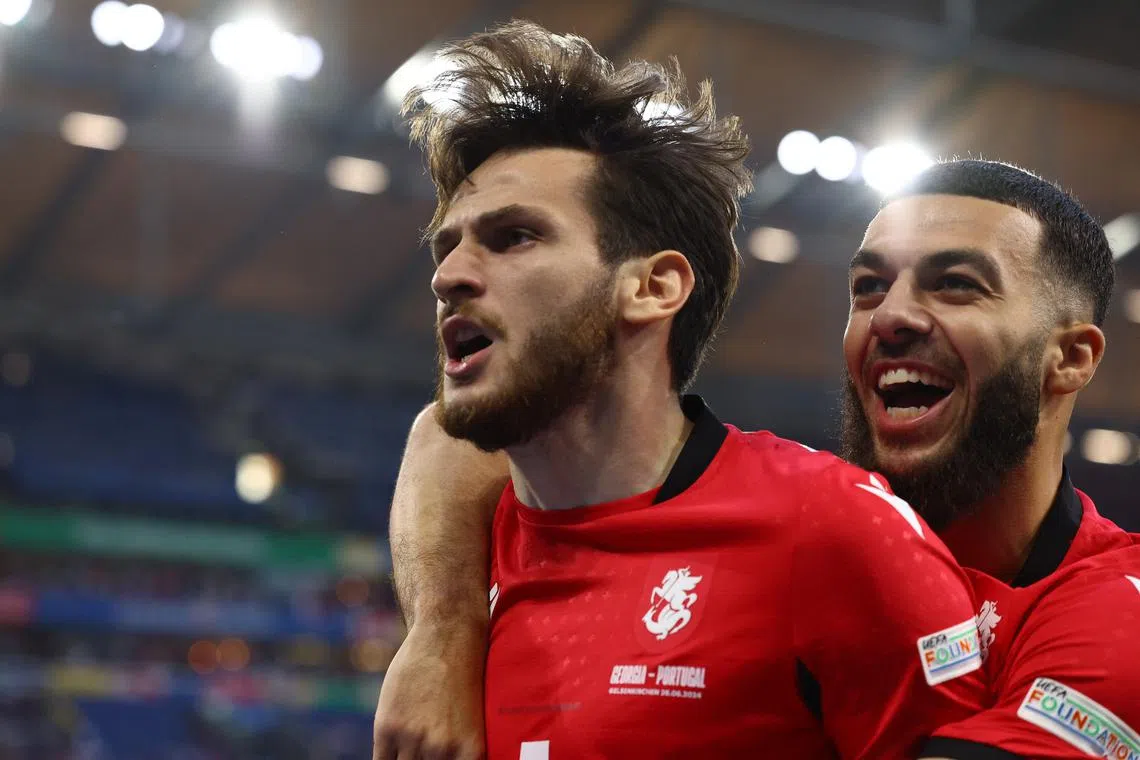 Soccer Football - Euro 2024 - Group F - Georgia v Portugal - Arena AufSchalke, Gelsenkirchen, Germany - June 26, 2024  Georgia's Khvicha Kvaratskhelia celebrates scoring their first goal with Georges Mikautadze REUTERS/Bernadett Szabo