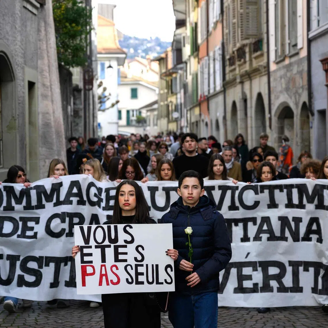 Protesters hold a silent march organised in memory of victims of the deadly New Year's Eve fire in Switzerland.
