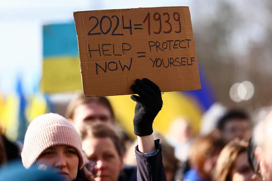 Thousands of people gathered in front of the Brandenburg Gate in Berlin, waving banners that read “Stand up for Ukraine” and “Arm Ukraine now”.