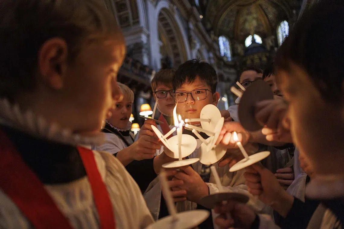 Choristers of St Paul's Cathedral lighting their candles as they take part in a rehearsal ahead of Advent and Christmas services in London, Britain, Dec 20, 2023. 
