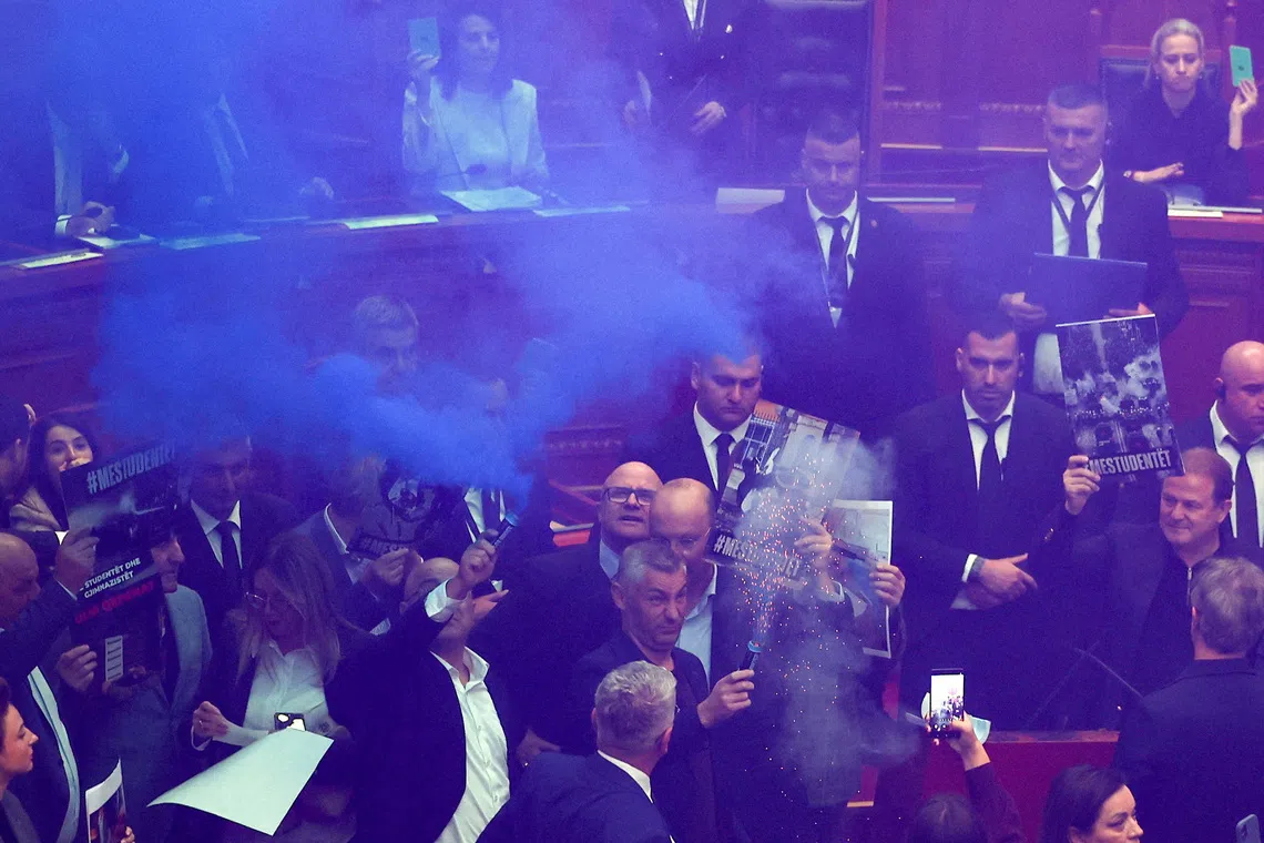 A person holds a flare as members of parliament from the Democratic Party, Albania's biggest opposition party, protest against the government inside the parliament in Tirana, Albania, October 29, 2026. REUTERS/Florion Goga