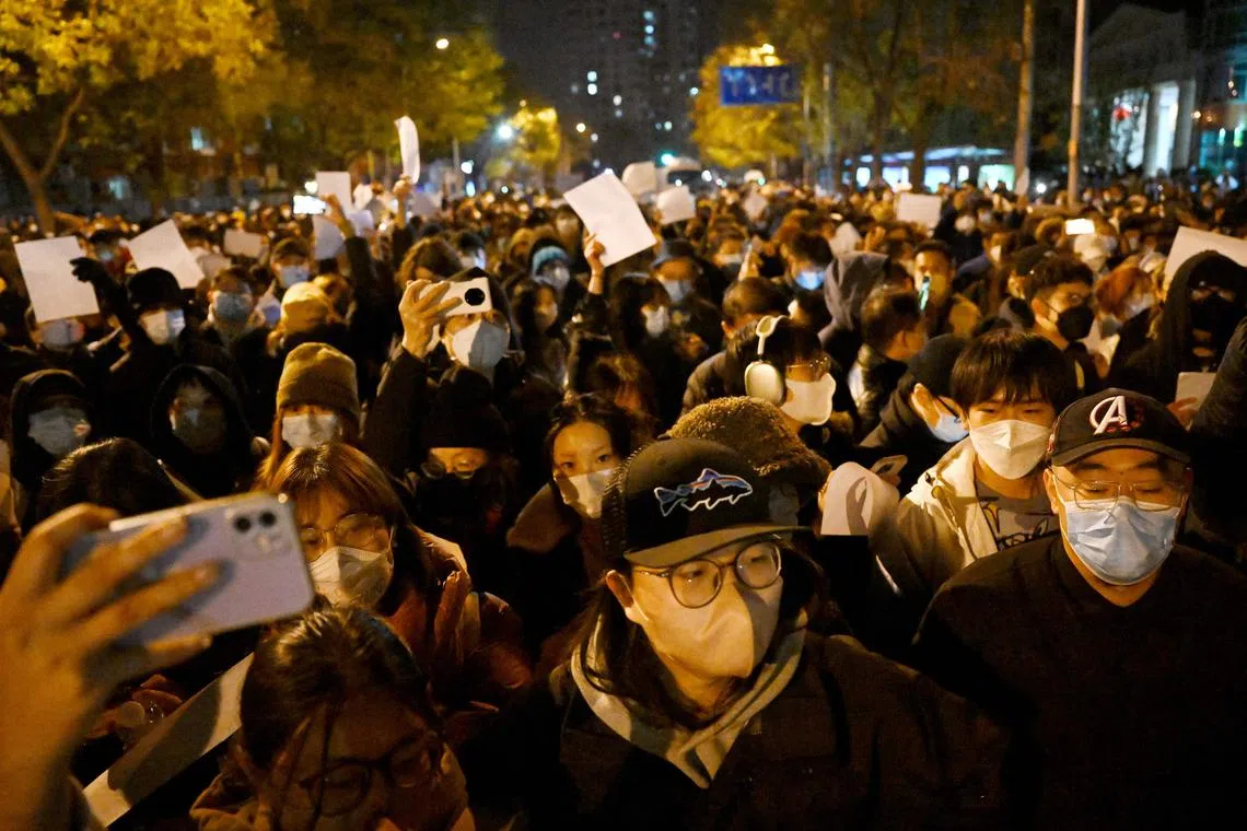 Protesters marching along a street during a rally for the victims of a deadly fire as well as against China's harsh Covid-19 restrictions, in Beijing on Nov 28, 2022. 