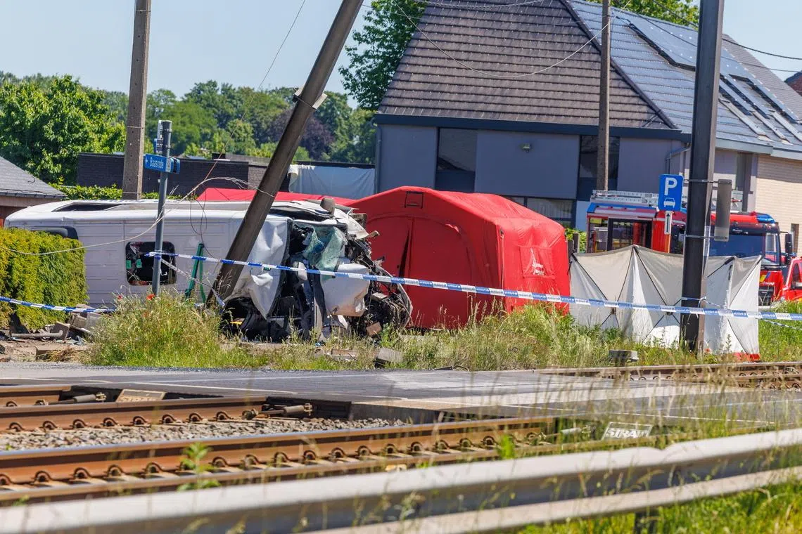 Images from the scene in the Flanders region showed a badly damaged minibus lying on its side on a road next to a railway line.