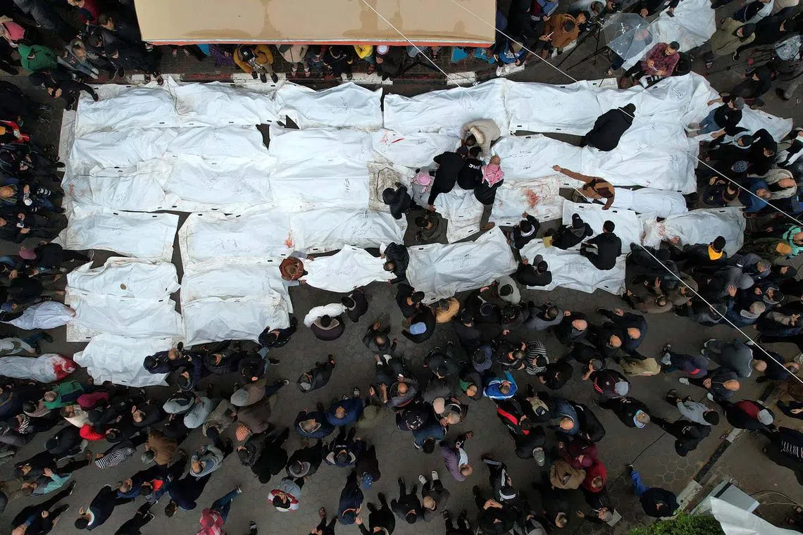 Palestinians mourning their relatives, killed in an overnight Israeli strike on the Al-Maghazi refugee camp, during a mass funeral at the Al-Aqsa hospital in Deir Al-Balah, in the southern Gaza Strip, on Dec 25, 2023, amid ongoing battles between Israel and the Palestinian militant group Hamas. 