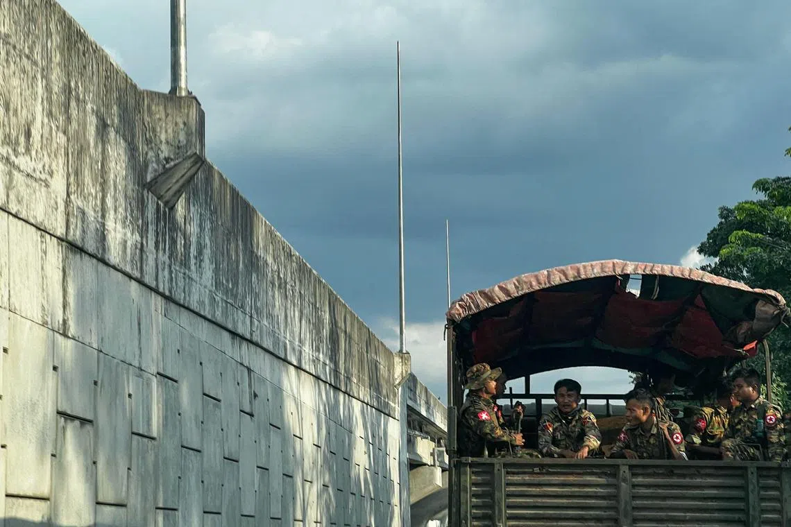 This photo taken on December 4, 2023 shows member of Myanmar's military patrolling on a truck down a street in Yangon. (Photo by AFP)