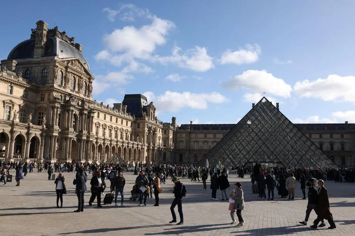 Tourists walk past the glass Pyramid of the Louvre Museum in Paris, France, November 2, 2023. REUTERS/Claudia Greco/File Photo