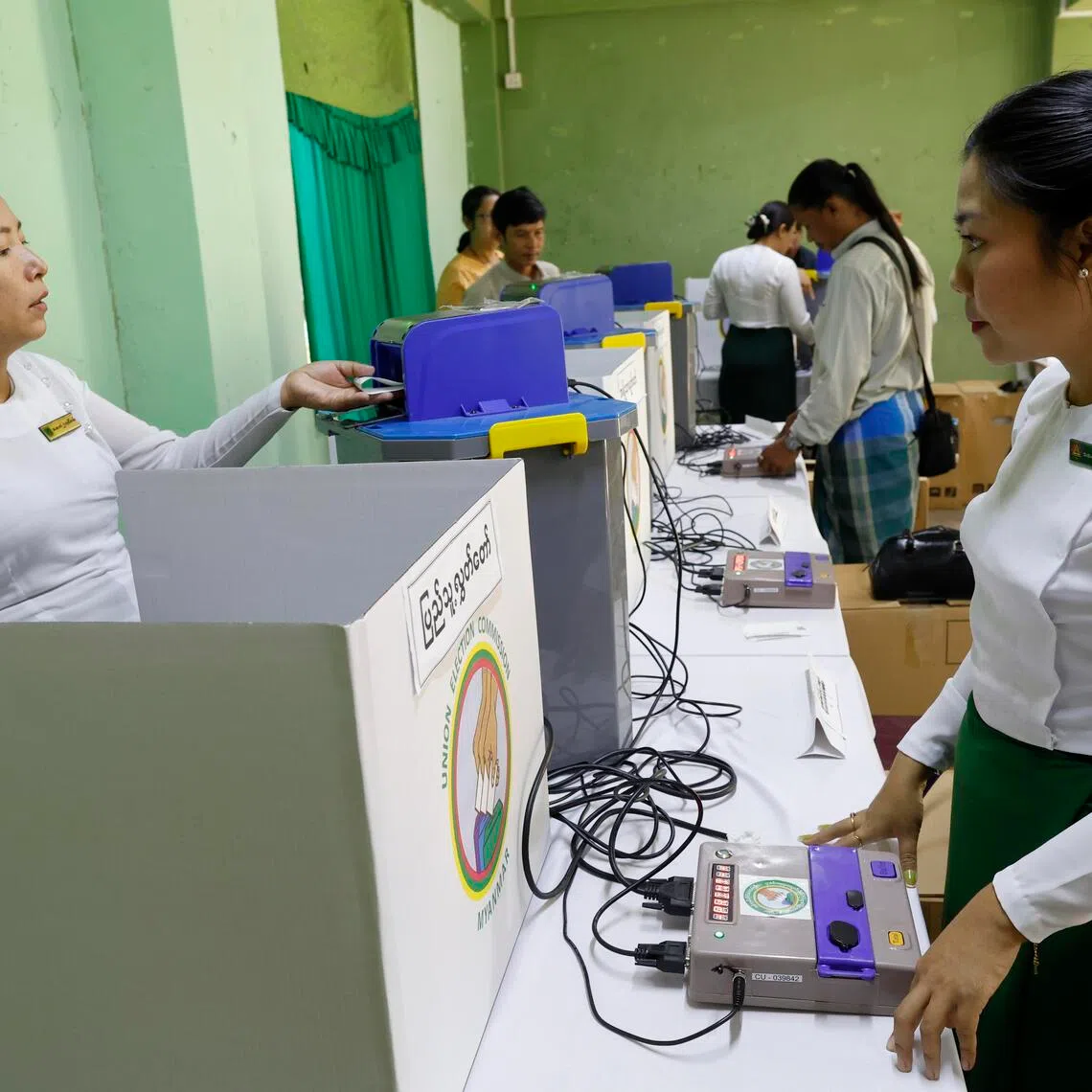 Myanmar electoral officials set up electronic voting machines at a polling station in Yangon, Myanmar, one day before the start of the third election phase.