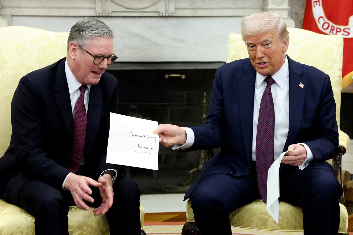 US President Donald Trump holds a letter from Britain's King Charles as he meets with British Prime Minister Keir Starmer at the White House in Washington, on Feb 27.