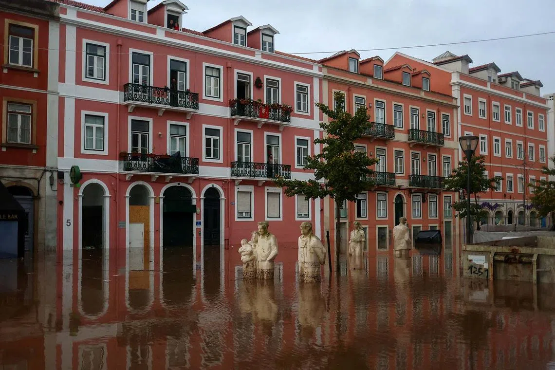 Submerged statues are seen in a flooded street in Alges, Oeiras, Portugal, December 13, 2022. REUTERS/Pedro Nunes TPX IMAGES OF THE DAY