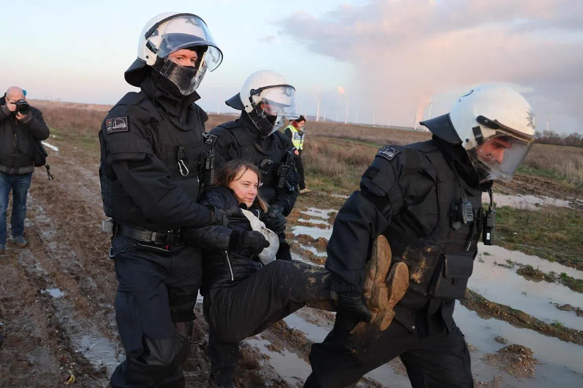 Police officers carry Swedish climate activist Greta Thunberg away from the protest area.