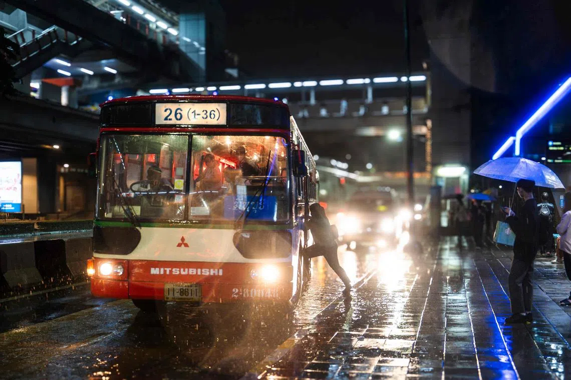 A women boards a bus during heavy rain in Bangkok on Sept 24, 2024.