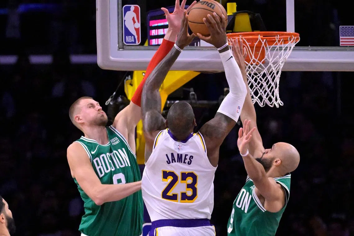 The Boston Celtics' Kristaps Porzingis (No. 8) and Derrick White defending a shot by Los Angeles Lakers' LeBron James in a Dec 25 clash.