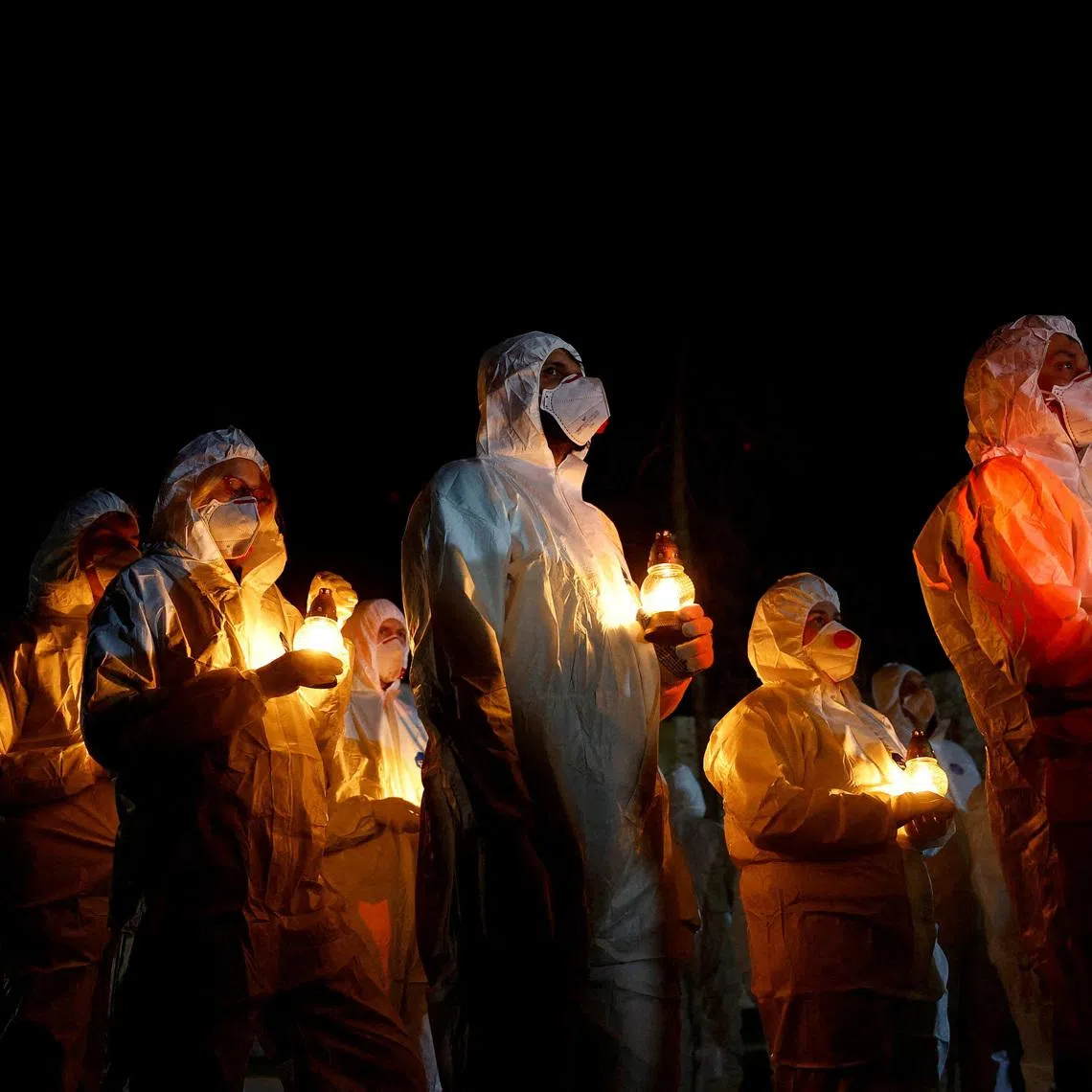 Members of the Chornobyl nuclear plant staff carry candles at a memorial dedicated to firefighters and workers who died after the 1986 Chornobyl nuclear disaster, during a night commemorative service to mark its 40th anniversary, amid Russia's attack on Ukraine, in Slavutych, Ukraine April 26, 2026. REUTERS/Valentyn Ogirenko