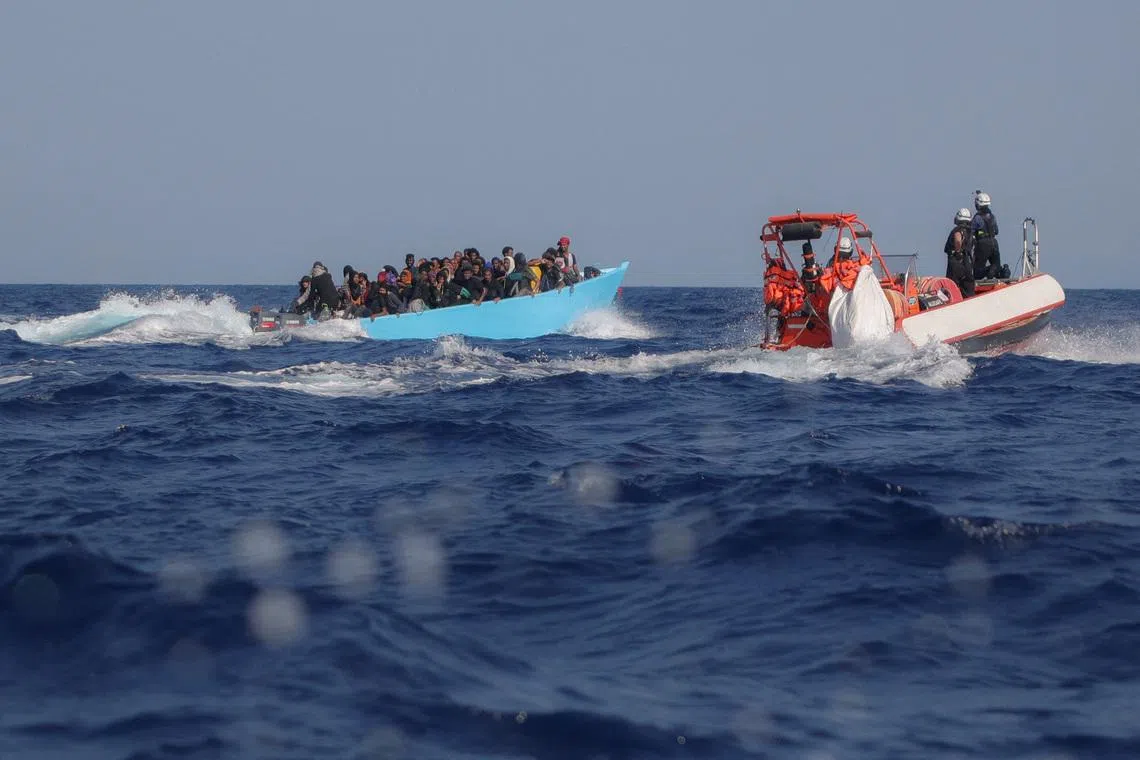 FILE PHOTO: Migrants aboard an overcrowded boat are approached by the crew of the migrant search and rescue ship Sea-Watch 5, operated by the German NGO Sea-Watch, during a rescue operation in the Search and Rescue (SAR) zone in the central Mediterranean, off Libya, August 11, 2025. REUTERS/Louisa Gouliamaki/File Photo
