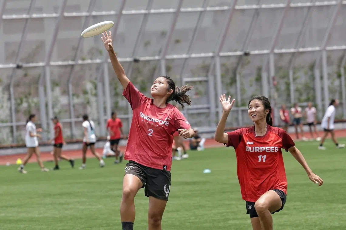 National ultimate frisbee mixed team player Jodie Soh (left) making a catch in mid-air during training.