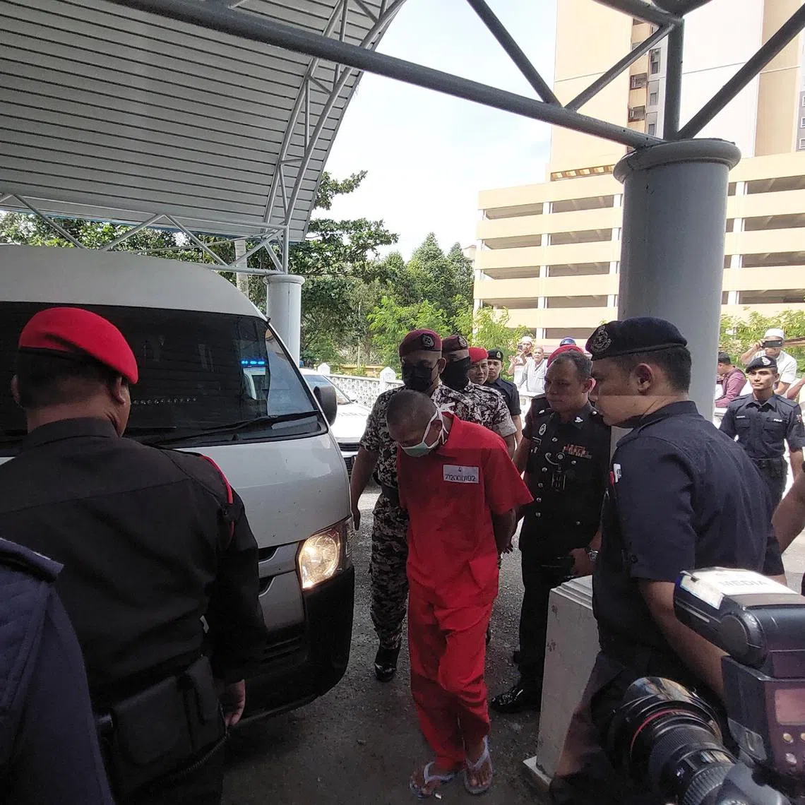 Carpenter Mohd Affendi Awang being escorted by prison officers to a room at a mosque in Kuala Terengganu to receive six lashes for a syariah offence.
