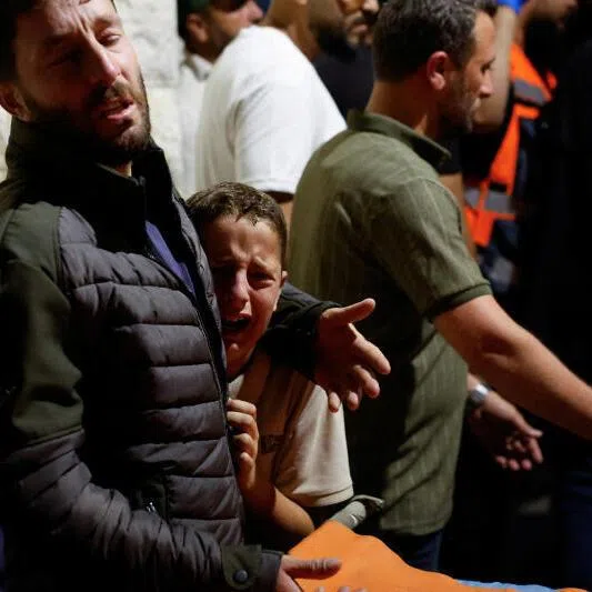 Palestinians react next to the bodies of Palestinians, who were killed in a deadly shooting incident near the village of Tal in Nablus, West Bank, during their funeral on July 25.
