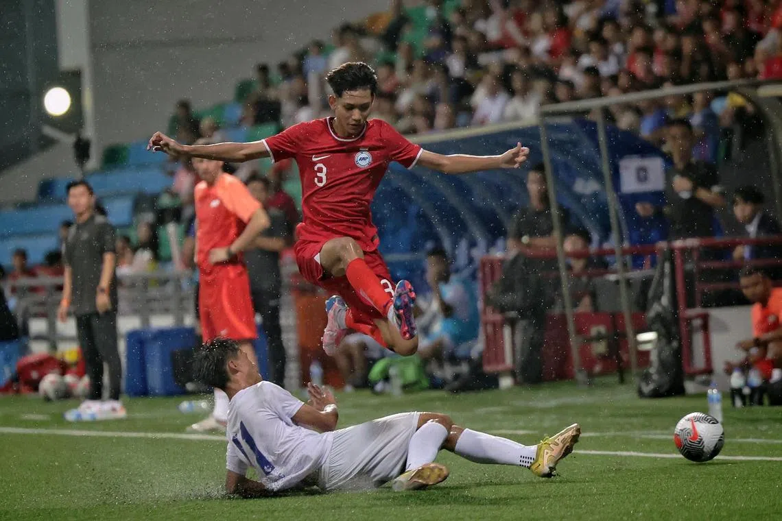 Singapore U-16's Luth Harith Fathi hurdles over a tackle by BG Pathum's Thunwisit Taman in the Lion City Cup semi-final at Jalan Besar Stadium on Oct 4, 2024.
