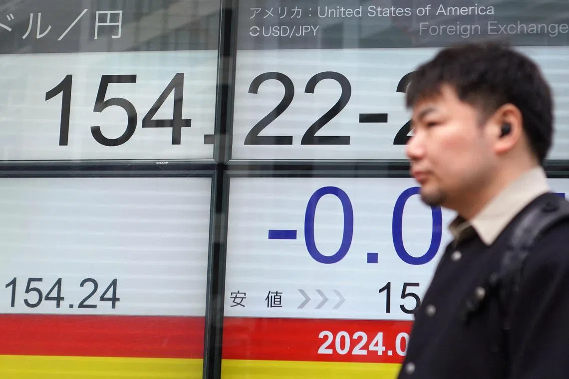 A man walks past an electronic board showing the rate of the Japanese yen versus the US dollar in Tokyo on April 16.