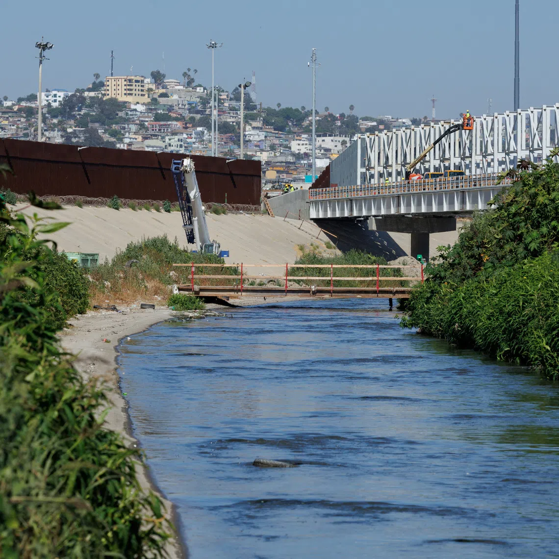 Raw sewage flows along the Tijuana river located between the primary and secondary borders next to Tijuana, Mexico in San Diego, California, U.S., June 27, 2024.  REUTERS/Mike Bake
