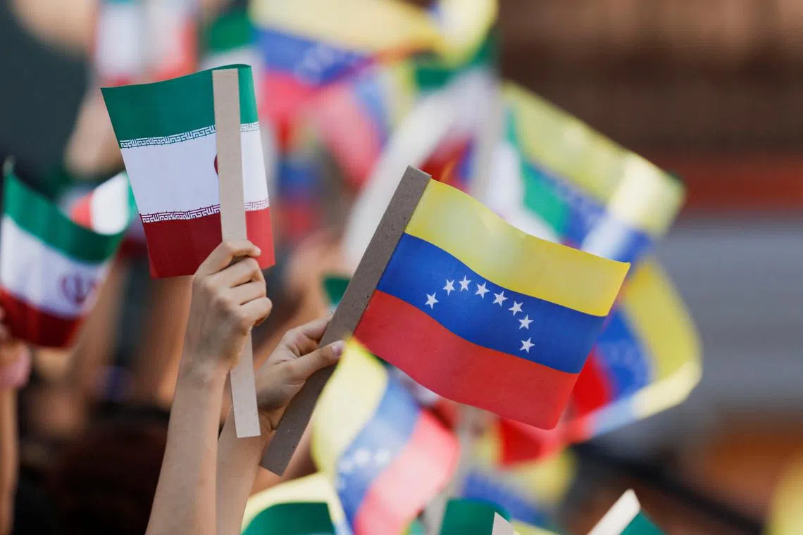 People hold flags as Venezuela's President Nicolas Maduro meets with Iranian President Ebrahim Raisi, at Miraflores Palace, in Caracas, Venezuela June 12, 2023. REUTERS/Leonardo Fernandez Viloria/File photo