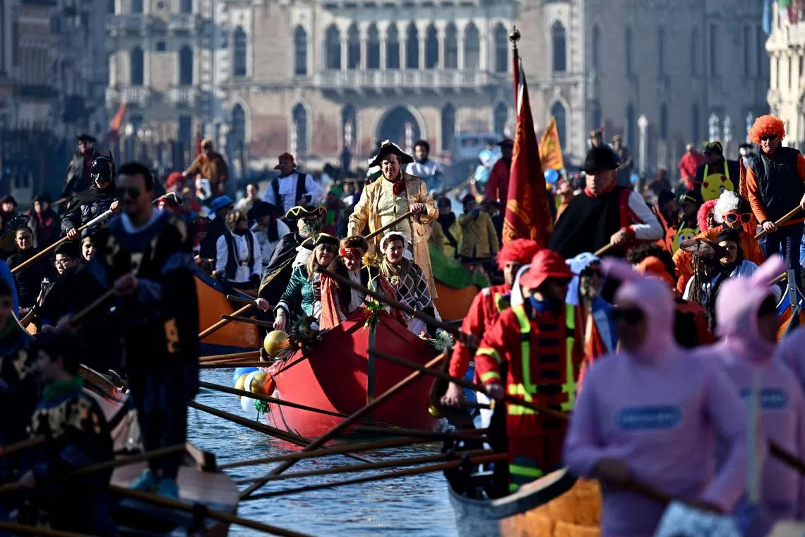 Dressed up revellers sailing their decorated boats on the Grand Canal during the traditional parade of the Coordination of Venetian Rowing Associations, as part of the Venice carnival on Jan 28, 2024.